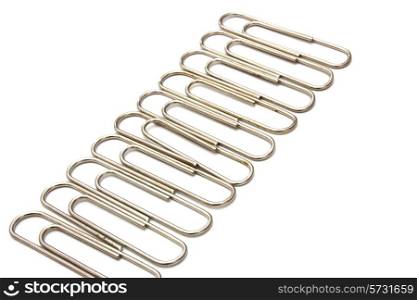The metal paper clip lies on a white background