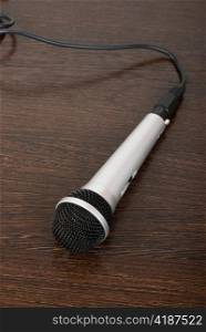 The microphone on a brown wooden background