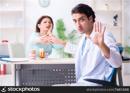 The middle-aged woman visiting male doctor stomatologist. Middle-aged woman visiting male doctor stomatologist