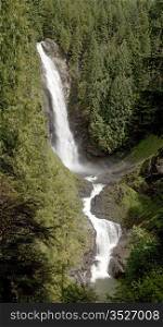 The middle waterfall of Wallace Falls in Washington State goes through two different stages in the middle of a forest.