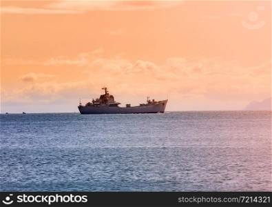 The military ship on ocean at sunrise