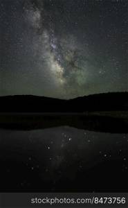 The Milky Way reflects in Spruce Knob Lake as the dark sky reveals the the faint green air glow high in the atmosphere.