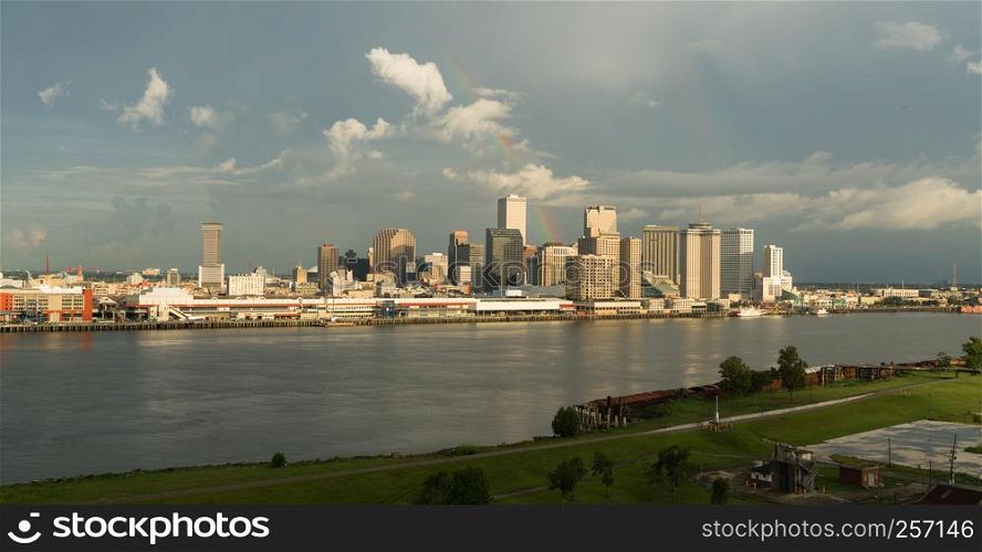 The Mississippi River flows by the New Orleans waterfront storm clearing rainbow glowing