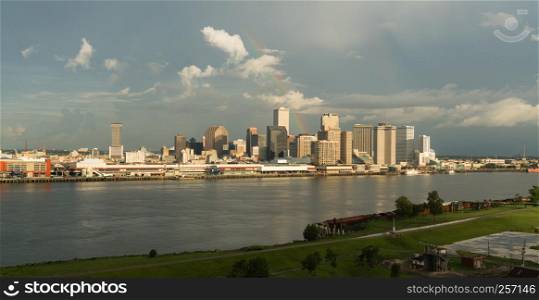 The Mississippi River flows by the New Orleans waterfront storm clearing rainbow glowing