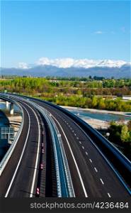 The Modern Highway in Piedmont on the Background of Snow-capped Alps, Italy