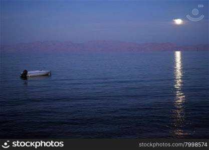 The Moon and motor boat at night in Dahab, Egypt