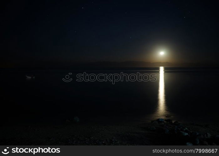 The Moon and motor boat at night in Dahab, Egypt