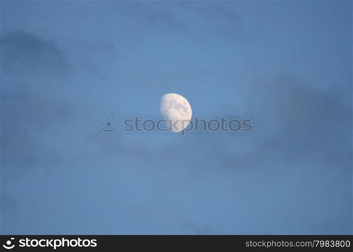 The moon with blue sky and dark clouds