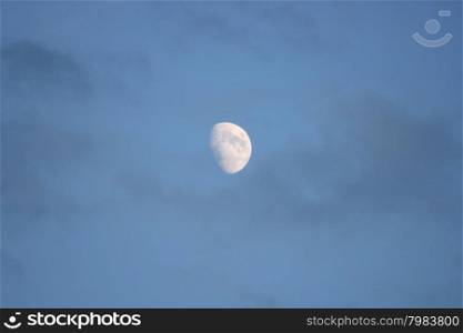 The moon with blue sky and dark clouds