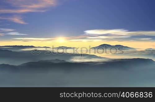 The morning blue sky pink and white clouds. Due to foggy horizon rises bright white sun. Above the valley floating clouds in the valleys between the hills and mountains of glowing fog.