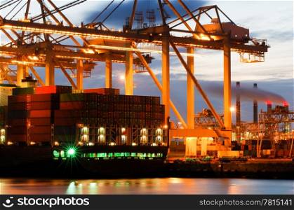The motion and activity of a container terminal at dusk, with all fascets of the harbor: the ships, the containers, the cranes, the carriers, the processing industry.
