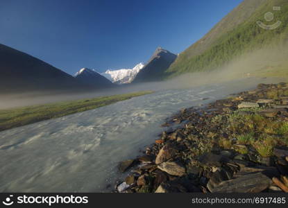 The mountain river in the mountains. Current through the gorge the river. Stones and rocky land near the river. Beautiful mountain landscape. The mountain river in the mountains. Current through the gorge the river. Stones and rocky land near the river. Beautiful mountain landscape.