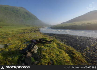 The mountain river in the mountains. Current through the gorge the river. Stones and rocky land near the river. Beautiful mountain landscape. The mountain river in the mountains. Current through the gorge the river. Stones and rocky land near the river. Beautiful mountain landscape.