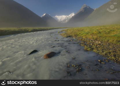 The mountain river in the mountains. Current through the gorge the river. Stones and rocky land near the river. Beautiful mountain landscape. The mountain river in the mountains. Current through the gorge the river. Stones and rocky land near the river. Beautiful mountain landscape.