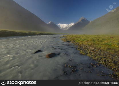 The mountain river in the mountains. Current through the gorge the river. Stones and rocky land near the river. Beautiful mountain landscape. The mountain river in the mountains. Current through the gorge the river. Stones and rocky land near the river. Beautiful mountain landscape.