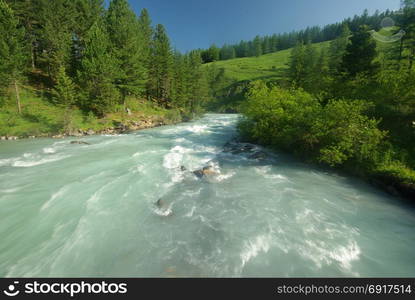 The mountain river in the mountains. Current through the gorge the river. Stones and rocky land near the river. Beautiful mountain landscape. The mountain river in the mountains. Current through the gorge the river. Stones and rocky land near the river. Beautiful mountain landscape.