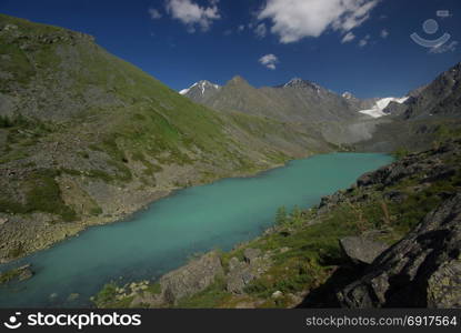 The mountain river in the mountains. Current through the gorge the river. Stones and rocky land near the river. Beautiful mountain landscape. The mountain river in the mountains. Current through the gorge the river. Stones and rocky land near the river. Beautiful mountain landscape.