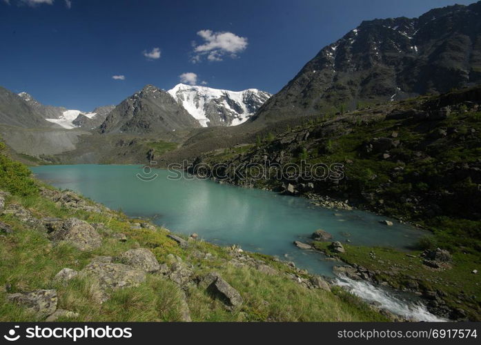 The mountain river in the mountains. Current through the gorge the river. Stones and rocky land near the river. Beautiful mountain landscape. The mountain river in the mountains. Current through the gorge the river. Stones and rocky land near the river. Beautiful mountain landscape.