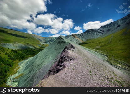 The mountain river in the mountains. Current through the gorge the river. Stones and rocky land near the river. Beautiful mountain landscape. The mountain river in the mountains. Current through the gorge the river. Stones and rocky land near the river. Beautiful mountain landscape.