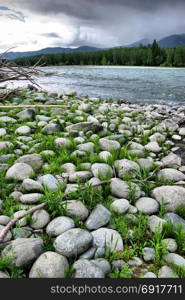 The mountain river in the mountains. Current through the gorge the river. Stones and rocky land near the river. Beautiful mountain landscape. The mountain river in the mountains. Current through the gorge the river. Stones and rocky land near the river. Beautiful mountain landscape.