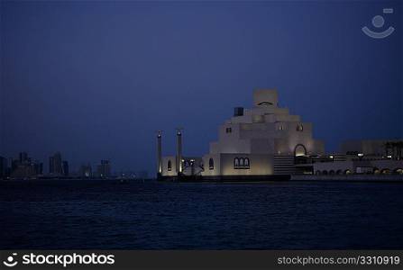 The Museum of Islamic Art in Doha, Qatar, at dusk, with the buildings of the New District still visible across the bay, early 2009.