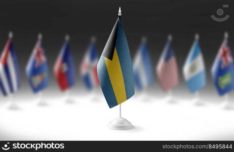 The national flag of the Bahamas on the background of flags of other countries.. The national flag of the Bahamas on the background of flags of other countries