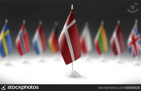 The national flag of the Denmark on the background of flags of other countries.. The national flag of the Denmark on the background of flags of other countries