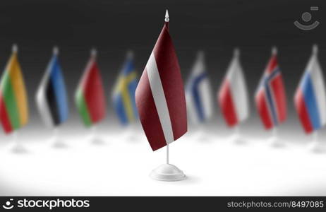 The national flag of the Latvia on the background of flags of other countries.. The national flag of the Latvia on the background of flags of other countries