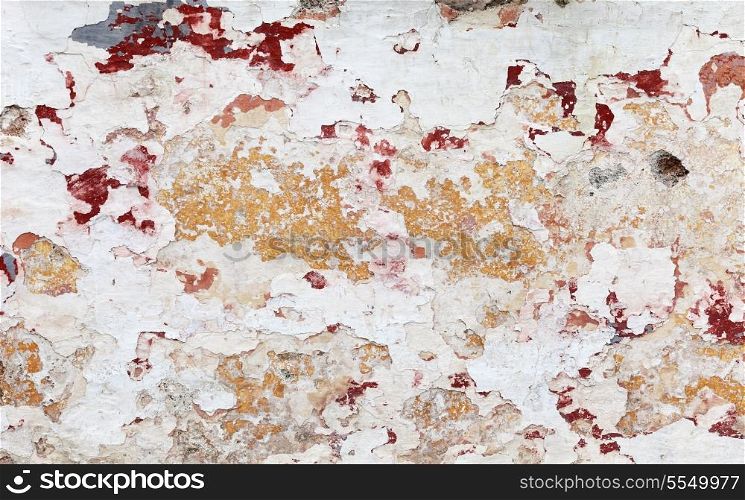 The naturally peeling paint and plaster on a wall in the Greek island of Hydra