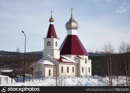 The new building of the Orthodox Church in the background of the winter forest