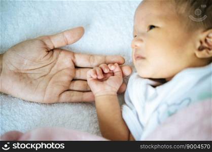 The newborn baby opens his eyes and puts the hand on the mother&rsquo;s hand
