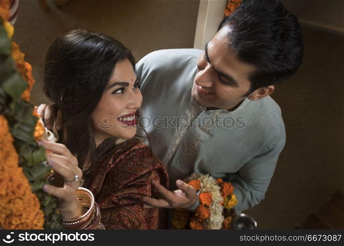 The newlywed couple in traditional dress performing rituals
