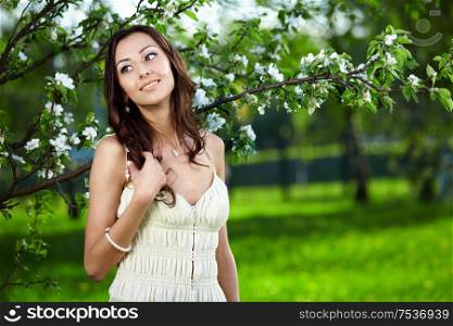 The nice girl in a dress against trees
