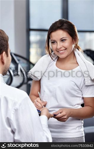 The nice young girl appends the signature in gym