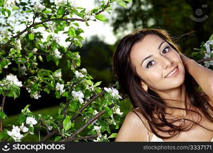The nice young girl in blossoming trees