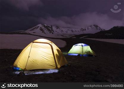The night before the ascent - the tents of tourists shine at the foot of Erciyes Dag in central Anatolia, Turkey.. Tents of tourists are located at the foot of Mount Erciyes in central Turkey