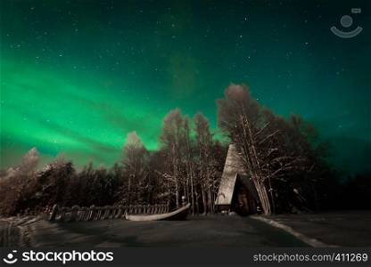 The northern lights Aurora Borealis at Kuukiuru village lake in Lapland, Finland.