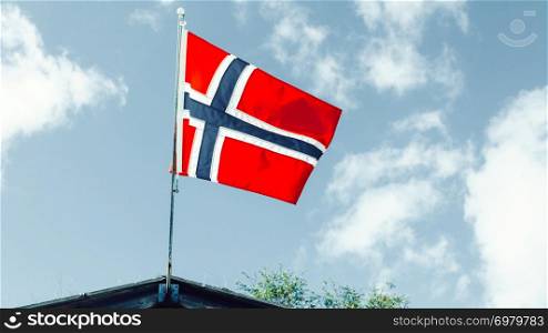 The norwegian flag waving against blue sky. The norwegian flag against blue sky