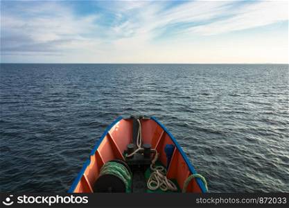 The nose of a small ship and the boundless calm of the White sea in an evening summer day.