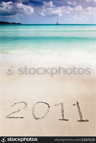 The number 2011 (two thousand and eleven) write in the sand of a tropical beach