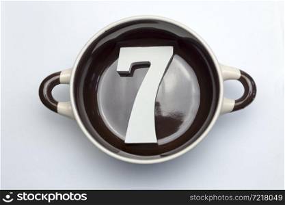 The number seven at the bottom of the soup tureen on white background.. The number seven at the bottom of the tureen.