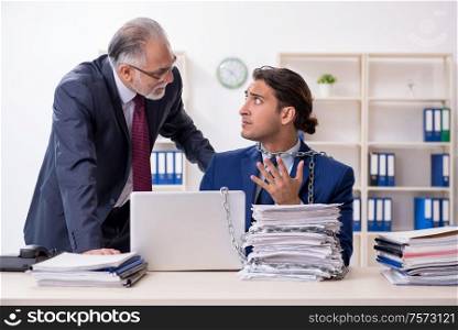 The old boss and young male employee in the office. Old boss and young male employee in the office