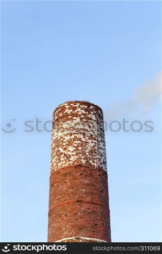 The old brick wall of the building, which is heated with coal and wood to produce heat and heat other buildings. Brick pipe sky