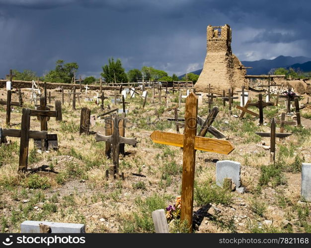 The old cemetery, surrounding the original church of San Geronimo, is filled with old graves. The graveyard is in sunlight while the dark sky looming in the background is a precursor to a thunderstorm.