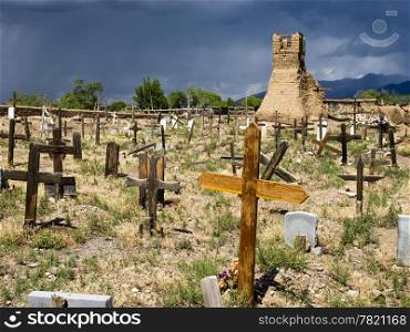 The old cemetery, surrounding the original church of San Geronimo, is filled with old graves. The graveyard is in sunlight while the dark sky looming in the background is a precursor to a thunderstorm.