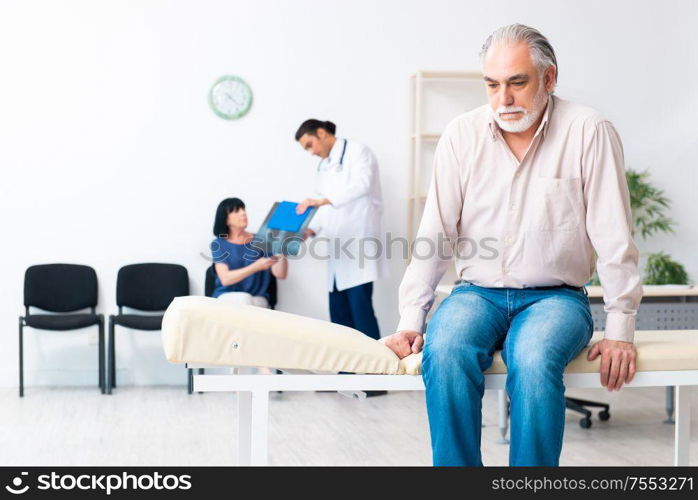 The old couple visiting young male doctor. Old couple visiting young male doctor