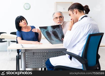 The old couple visiting young male doctor. Old couple visiting young male doctor