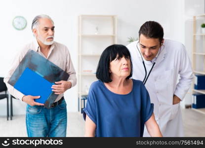 The old couple visiting young male doctor. Old couple visiting young male doctor