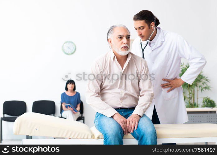 The old couple visiting young male doctor. Old couple visiting young male doctor