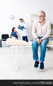 The old couple visiting young male doctor. Old couple visiting young male doctor